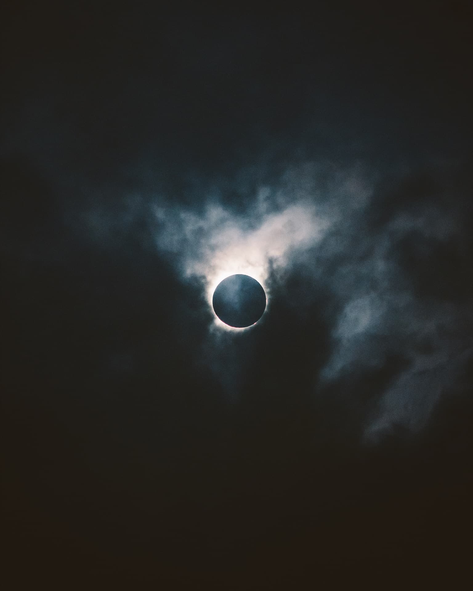 Solar eclipse with corona visible against dark sky